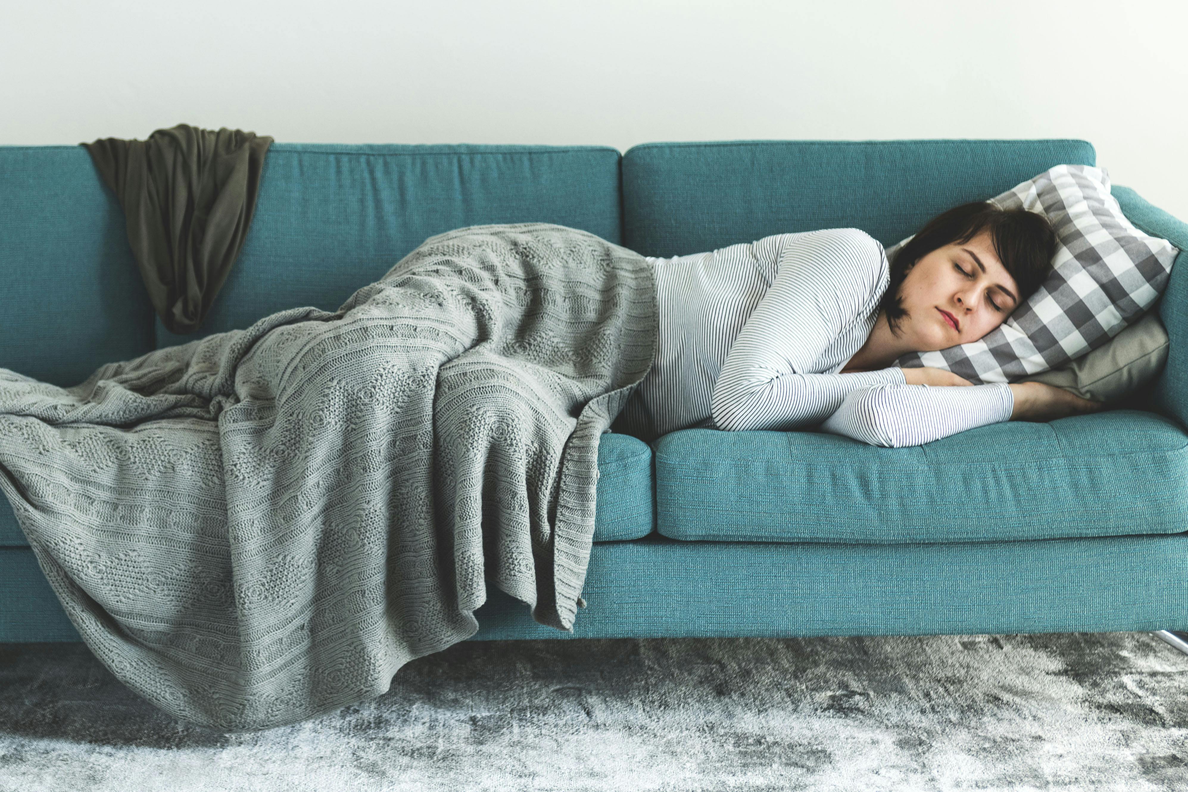 Nainen nukkuu sohvalla